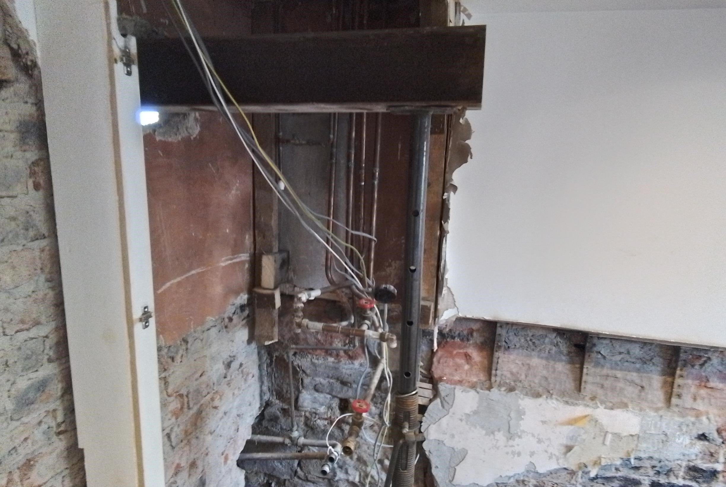 The cylinder and tank are removed from the bathroom during works to clean up and remediate the oil leak