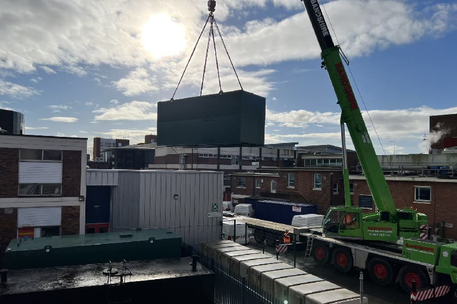 Bunded fuel storage tank being lifted into final position at a large hospital in North West England